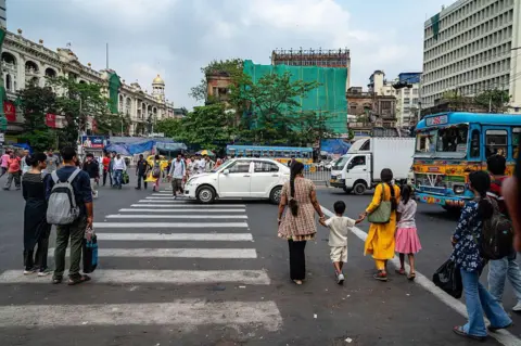 NurPhoto via Getty Images Traffic congestion and pedestrian safety issues are observed at the Dharmatala crossing in Kolkata.