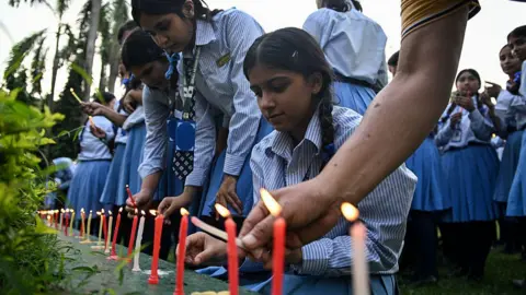 Getty Images Mourners and students light candles to offer their condolences after the death of mountaineer Nirmal Purja 