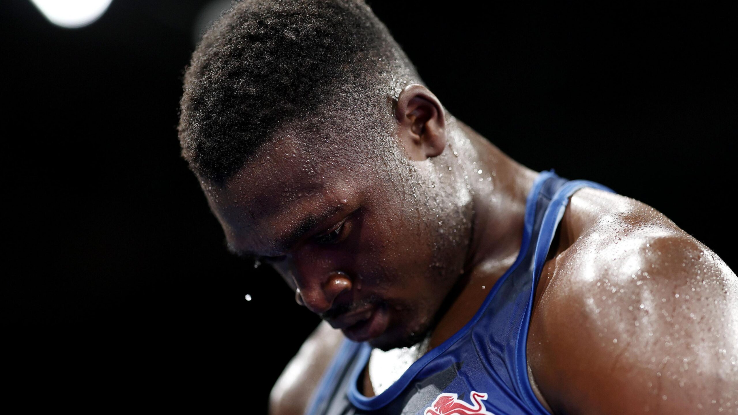 Dimeji Shittu, wearing a blue vest, looks down
