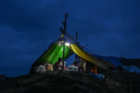 Getty Images  Flood affected residents shelter inside a temporary tent after being displaced by flooding on August 4, 2026 in Sivasagar district, Assam, India.