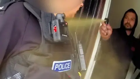 Man spraying an police officer in the face.