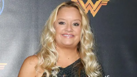 Getty Images Davis smiling at the camera in front of a Wonder Woman logo at the opening of the Wonder Woman Behind-The-Scenes Experience at Warner Bros Studios on July 31, 2017 in Burbank, California