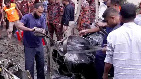 People clear debris at plane crash site