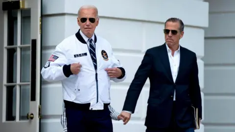 Getty Images Hunter Biden, son of US President Joe Biden, right, watches as US President Joe Biden gestures to his "Team USA" jacket on the South Lawn of the White House before boarding Marine One in Washington, DC, US, on Friday, July 26, 2024. 