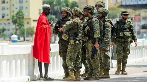 Reuters Spanish soldiers question a migrant, following mass crossings of migrants on foot and by sea