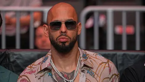 Getty Images Andrew Tate wearing a colorful shirt and glasses at a UFC event in April