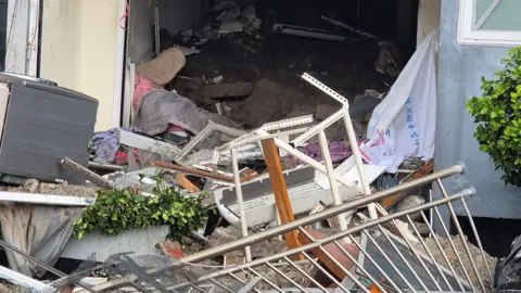 Yonhap News Agency via Reuters Debris is scattered after a landslide hits a housing unit