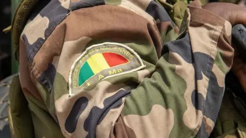 AFP via Getty Images A close up of a Mali army badge on the shoulder of a camouflage uniform.