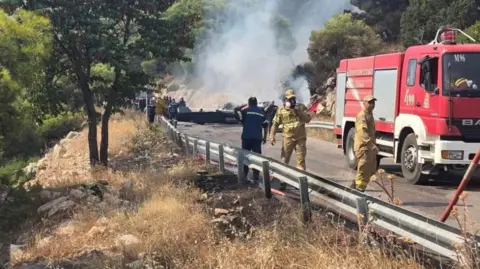 Shutterstock Firefighters and forensic experts work at the crash site after two firefighting helicopters collided mid-air west of Athens. Photo: 2 August 2026