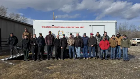 Supplied by Sonja Leverkus Members of the Northeast BC Rural Incident Management Team in front of a fire protection wagon they purchased using funds from donations and grants.