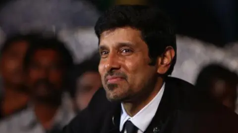 Getty Images Tamil actor Vikram, wearing a black coat, white shirt and a black tie, at the audio launch of one of his films in Chennai