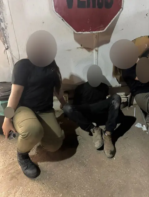 Social media Two Israeli soldiers pose with a blindfolded man.