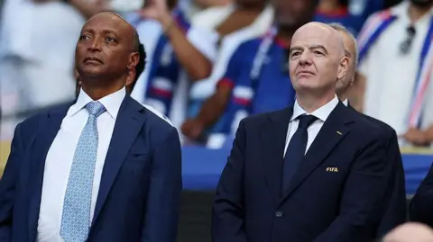 Getty Images President of the Confederation of African Football Patrice Motsepe and FIFA President Gianni Infantino are seen ahead of the 2026 World Cup Group H football match between Uruguay and Cape Verde at the Miami Stadium in Miami Gardens on June 21, 2026.