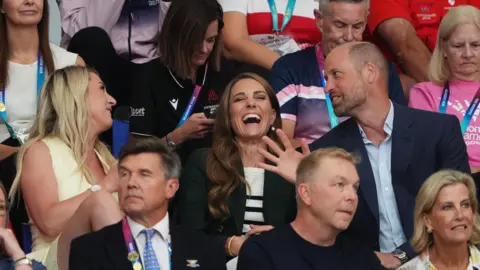 PA Media The Prince and Princess of Wales laughing in a crowd of spectators with British cyclist Laura Kenny. Chris Hoy sits in the row in front of them.