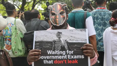 EPA A supporter of the satirical youth movement Cockroach Janta Party (CJP) holds a placard as people participate in a protest organized by CJP founder Abhijeet Dipke in New Delhi, India, 06 June 2026. 