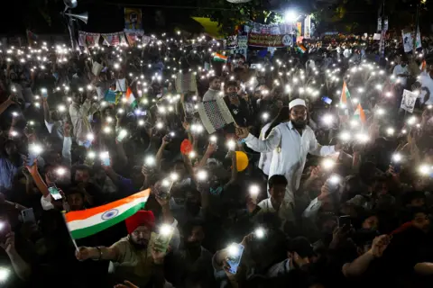 Reuters Supporters of the Cockroach Janta Party (CJP) chant slogans and wave their mobile phones with torches on as they gather after Indian education activist Sonam Wangchuk, who had been on a hunger strike, was taken to a hospital by authorities on Saturday during a sit-in protest demanding the resignation of Indian Education Minister Dharmendra Pradhan