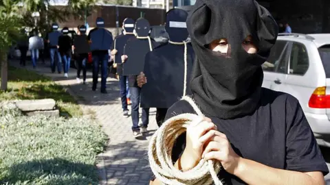 Anadolu Agency/Getty Images Protesters hold cardboard figures with ropes round their necks during a rally against the death penalty in Beirut, Lebanon. File photo from October 2013.