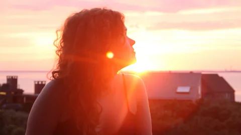 Mark Stetson Ally Hirschlag pictured looking off camera with beams of sunlight from the sunset behind her in Cape Cod (Credit: Mark Stetson)