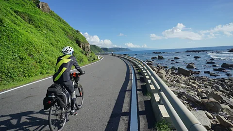 Getty Images A cyclist rides along a coastal road in Taiwan's Kenting National Park (Credit: Getty Images)